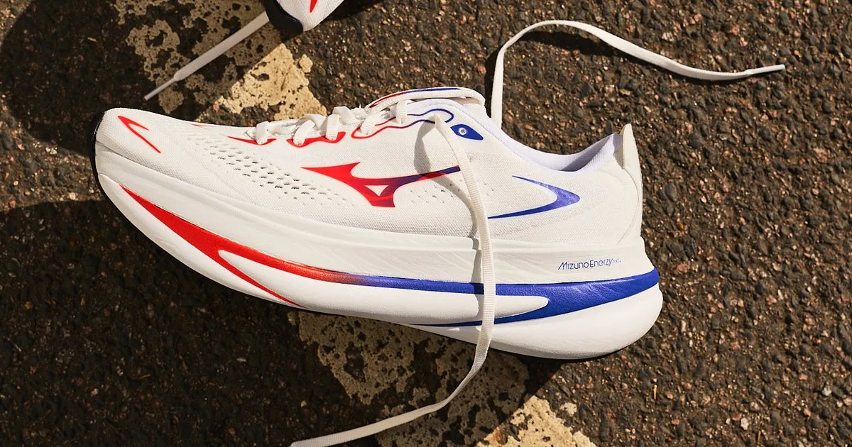 Mizuno Sky Prime de profil sur le bitume, coloris blanc avec bandes rouge et bleue et semelle intermédiaire Mizuno Enerzy NXT