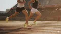 Deux coureurs en séance de vitesse sur piste illustrant la rotation des chaussures de running.