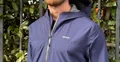 Veste imperméable KIPRUN Run 500 bleu marine portée après une sortie, zip et capuche en gros plan