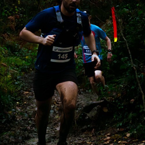 Coureur du Trail du Porteur d'Eau dans un sous-bois boueux de la forêt de Rennes