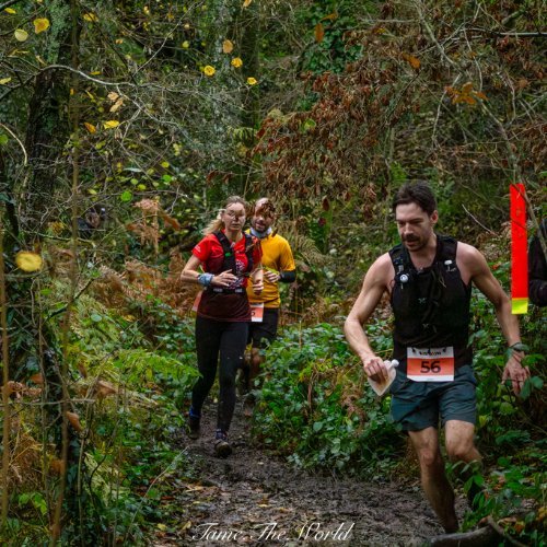 Coureur avec sa flasque à la main sur un single en sous-bois du Trail du Porteur d'Eau