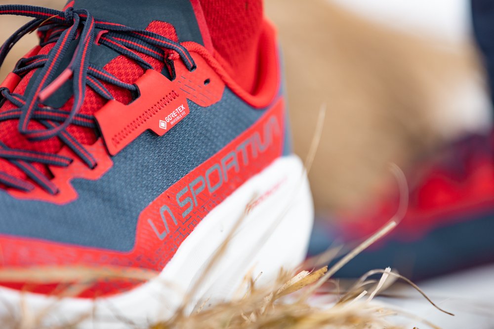 Le tirant GORE-TEX Invisible Fit, commun aux deux modèles Gros plan sur le talon de la Prodigio 2 GTX, coloris Nightsky/Mountain Red, avec le tirant GORE-TEX Invisible Fit